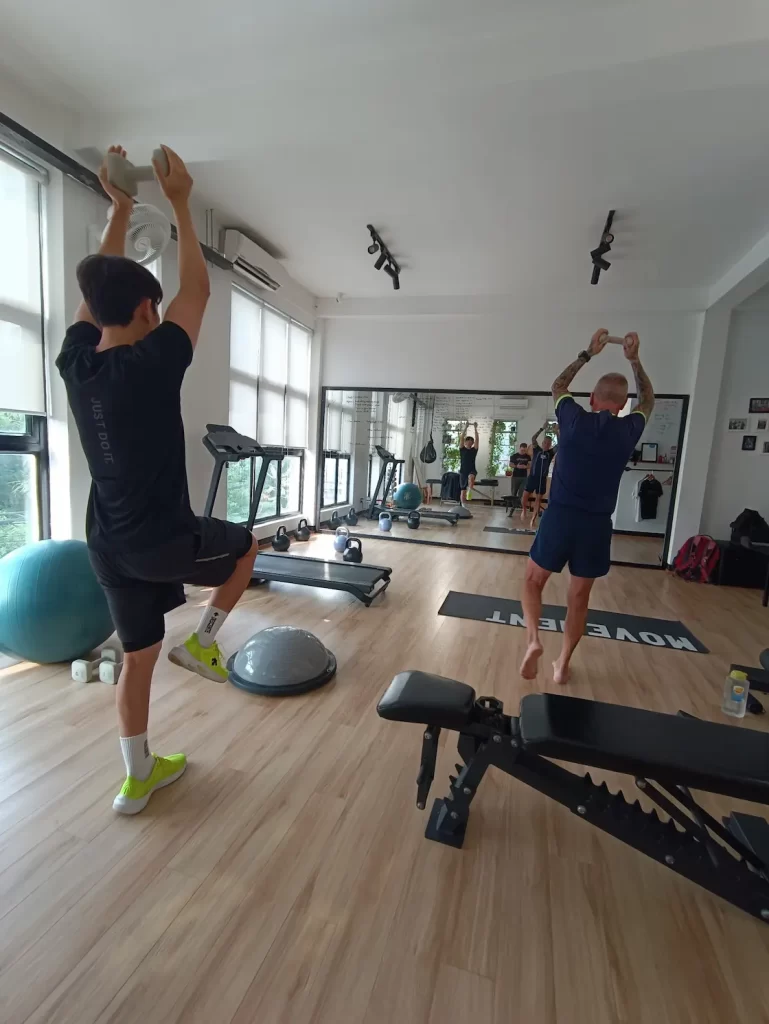 Personal trainer guiding a participant through strength training at Movement Phnom Penh.