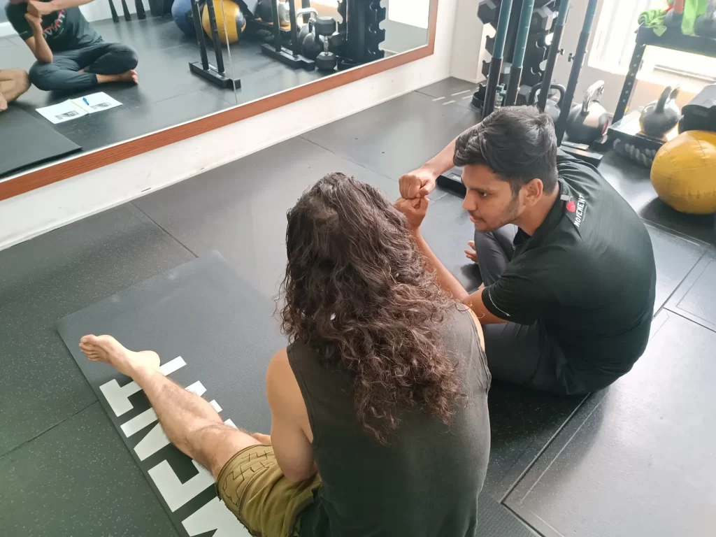 Patient learning movement retraining exercises for chronic back pain at Movement Cambodia.